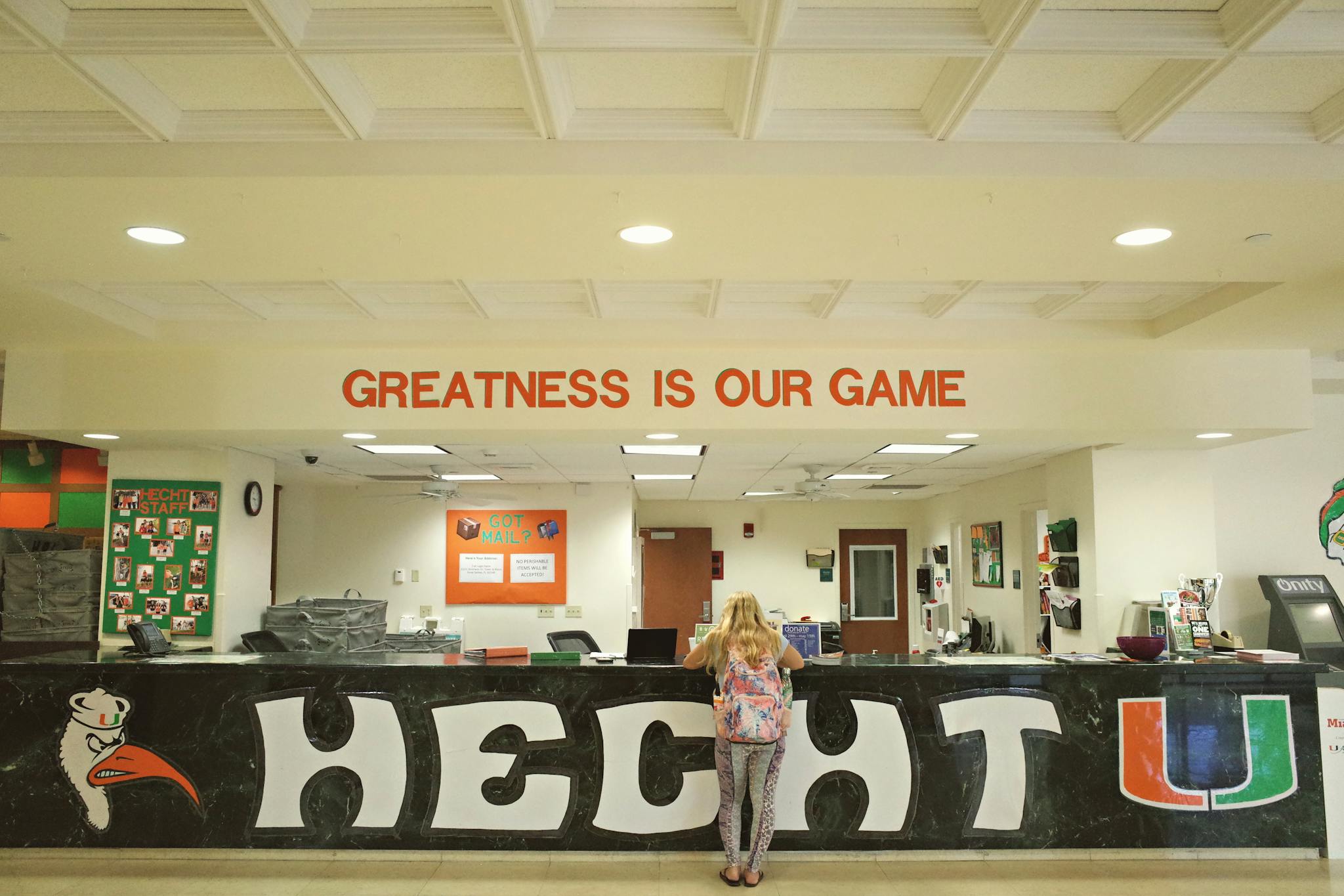 Bright university reception area featuring the slogan 'Greatness is Our Game' at Hecht U.